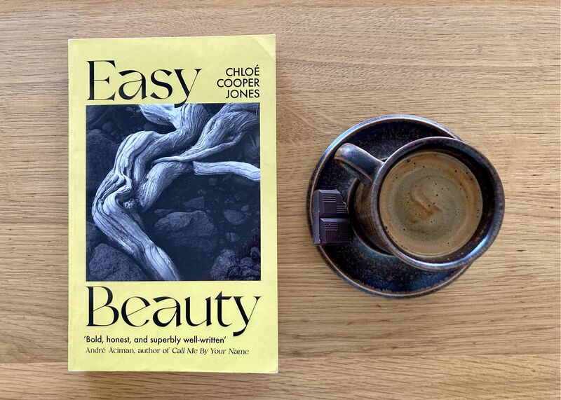Lichtgele cover van Easy Beauty met daarop een foto van verwrongen stuk hout. Ligt op houten tafel naast een kopje koffie.